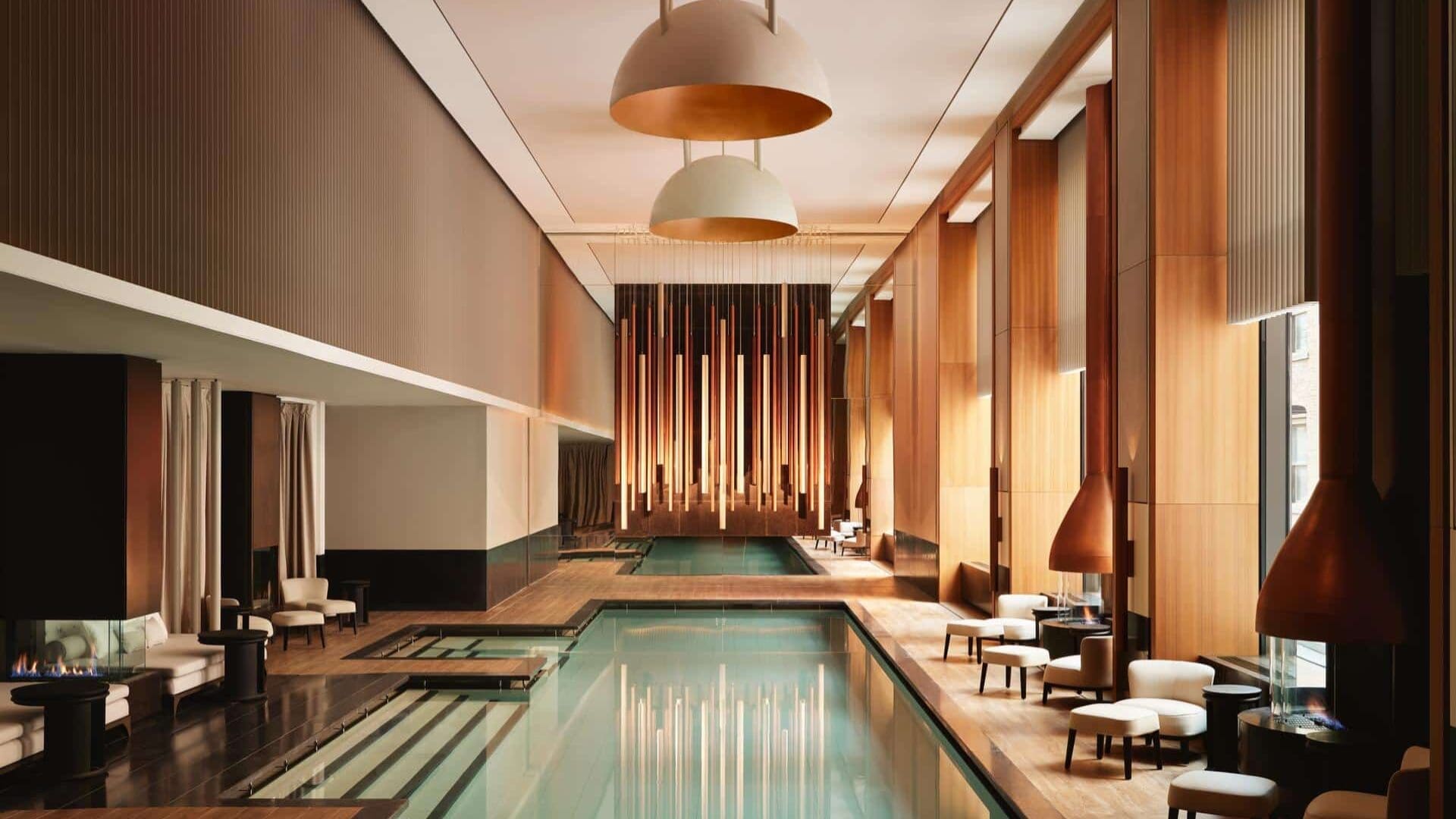 Aman New York rooftop infinity pool overlooking Central Park with skyline views and minimalist terrace seating
