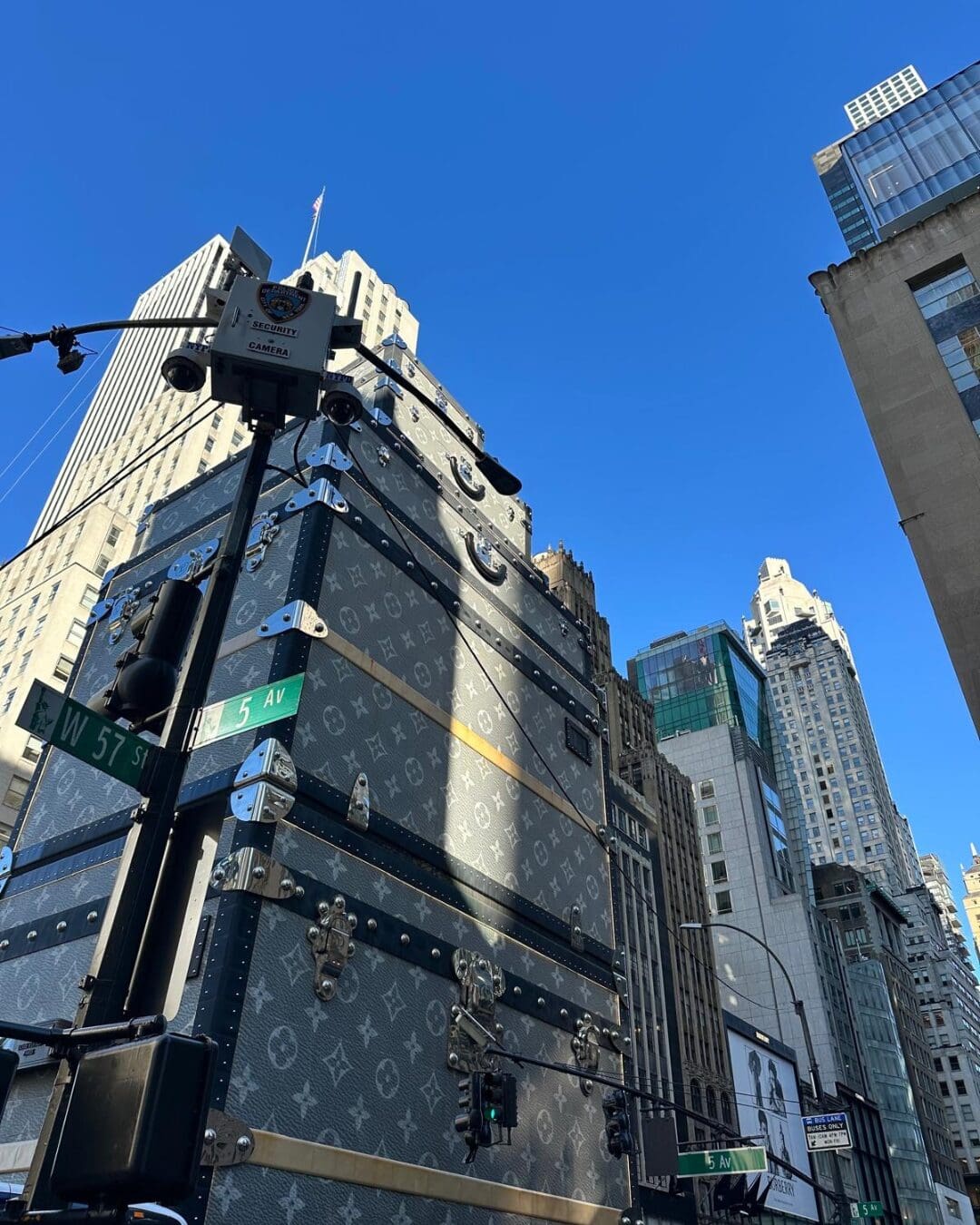 Louis Vuitton trunk installation on Fifth Avenue corner with NYC skyline and street signs at 57th Street