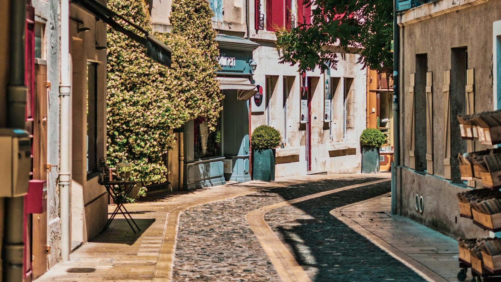 Cobblestone street with shops and stone buildings in a village in Provence, France